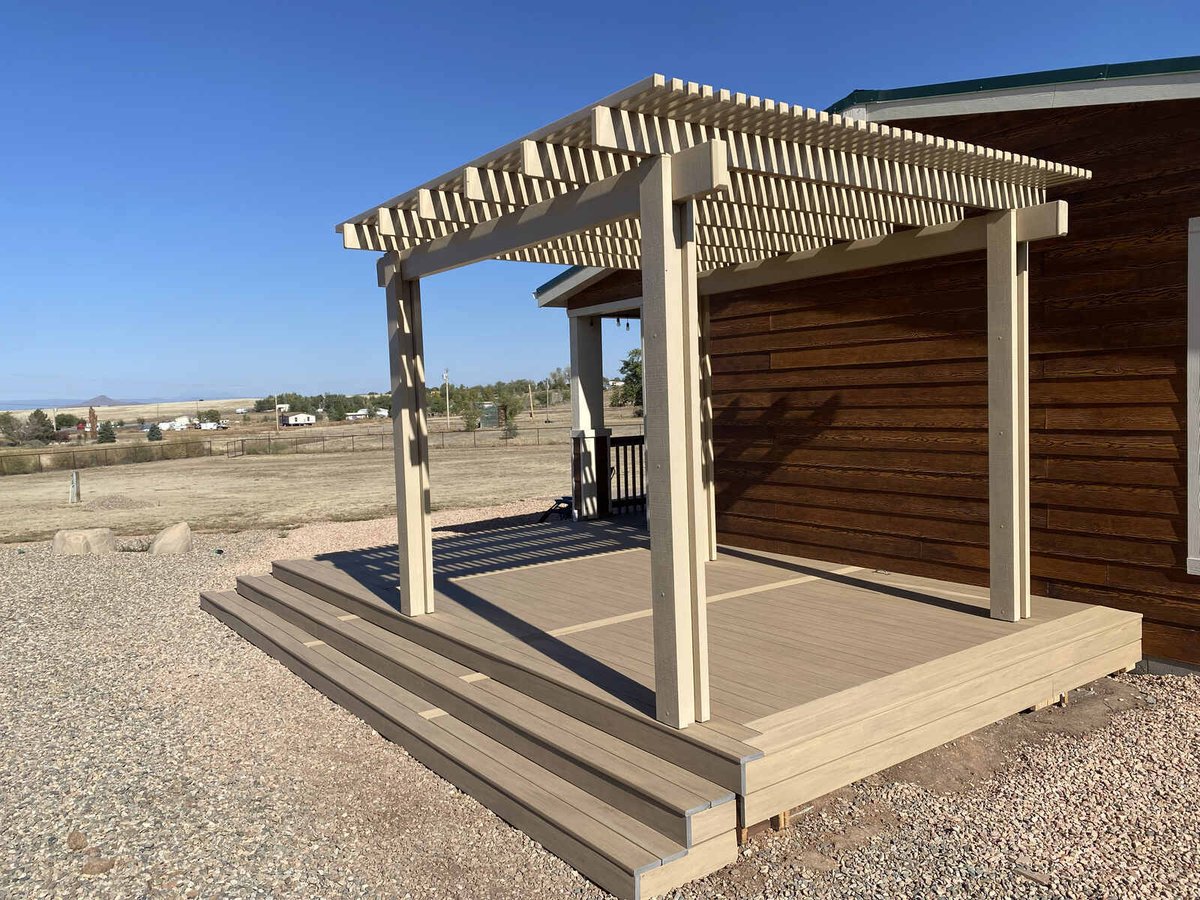 A wooden pergola over a newly built deck on a rural property by Crosby Home Services in Prescott, AZ