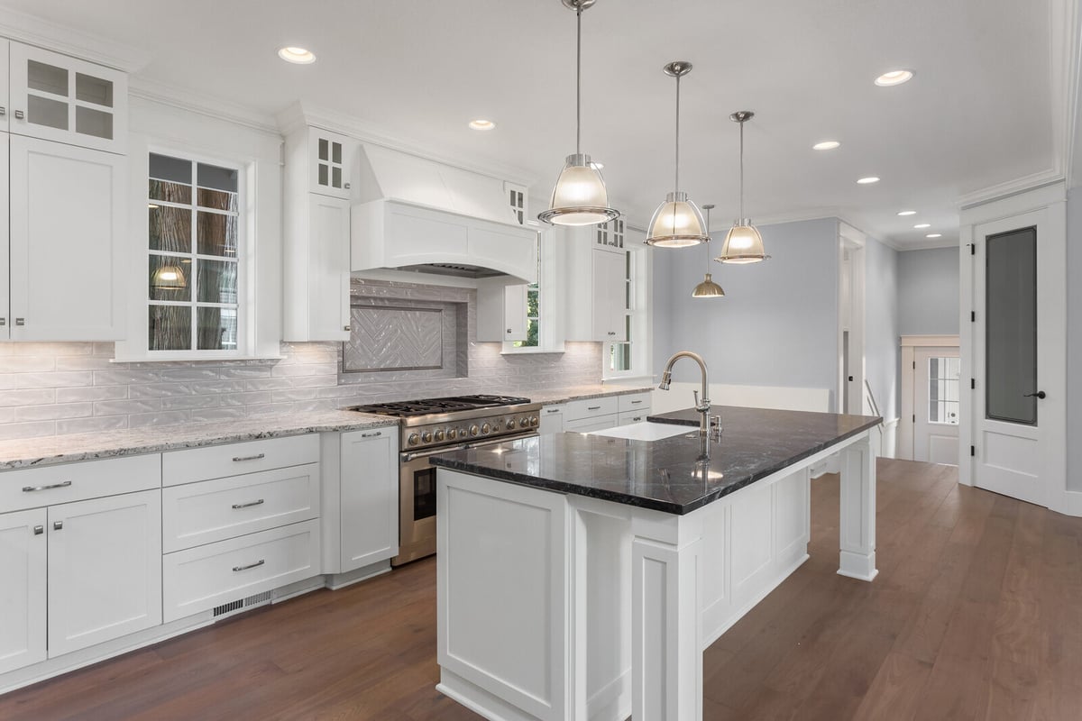 Elegant white kitchen remodel by Crosby Home Services in Prescott, AZ, featuring a spacious island and stainless steel appliances