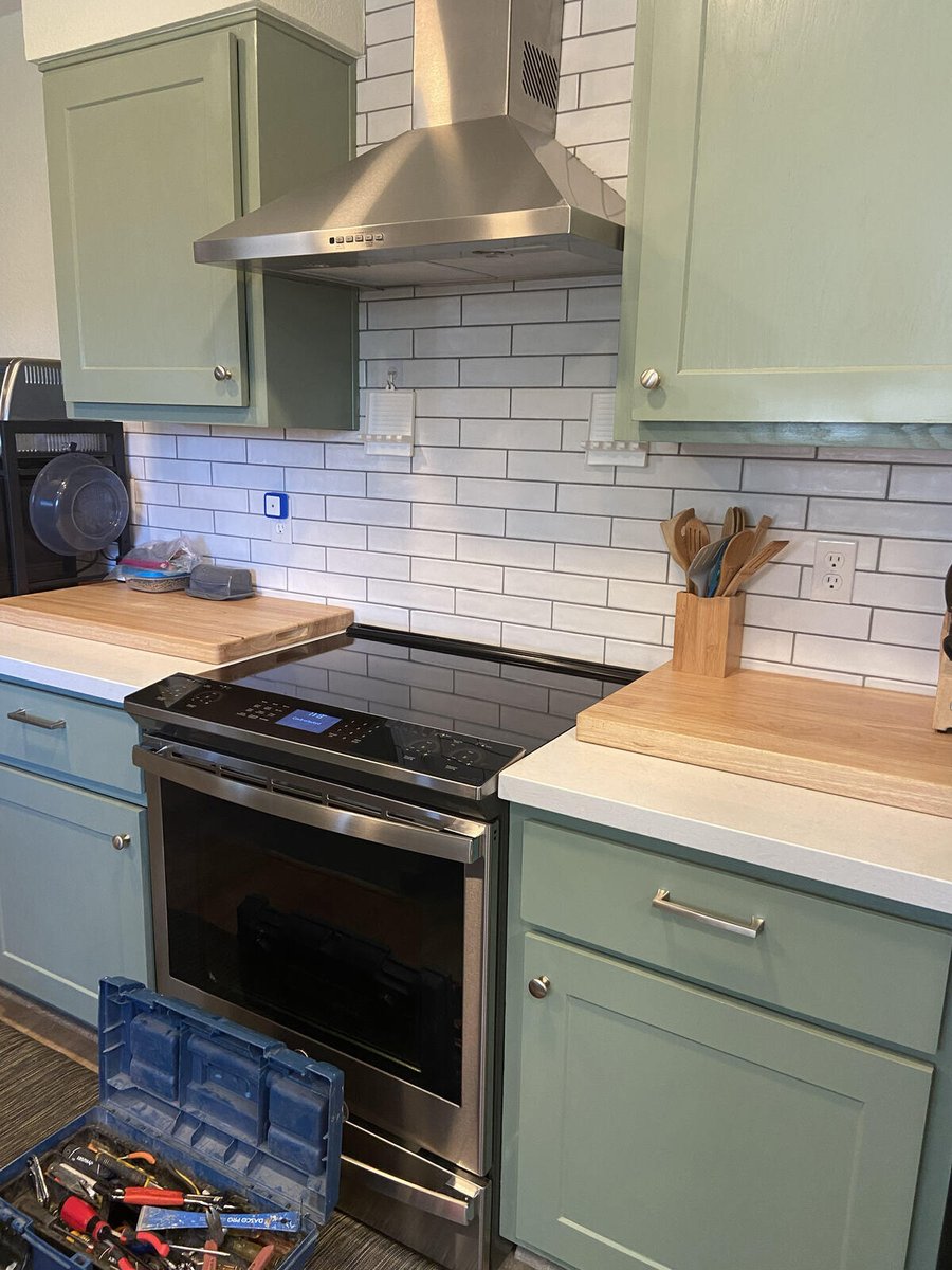 A remodeled kitchen with green cabinets and subway tile backsplash, completed by Crosby Home Services in Prescott, AZ