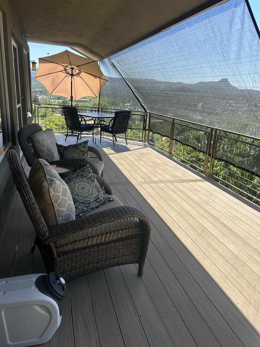 An elevated deck with sleek metal railings and partial shade by Crosby Home Services in Prescott, AZ